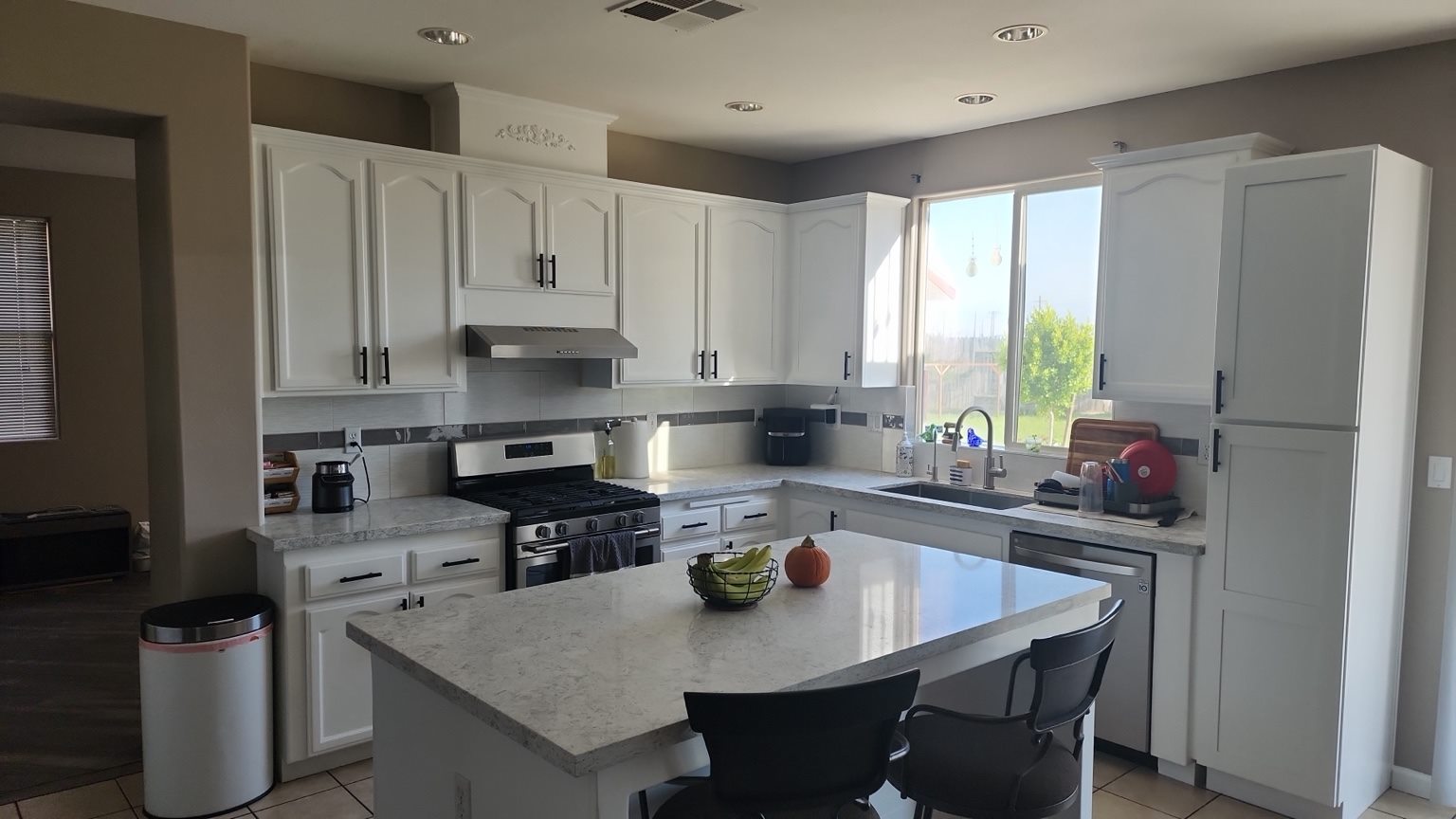 Completed kitchen remodel with white cabinets and island